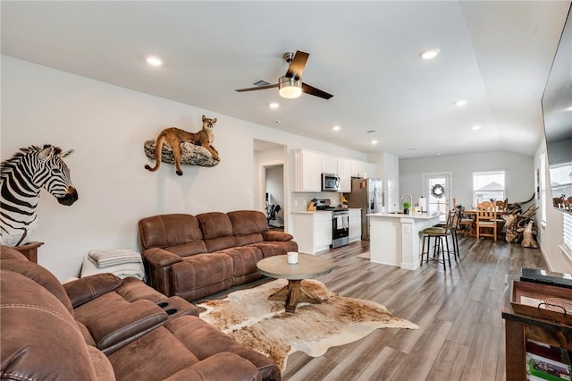 living room featuring ceiling fan, lofted ceiling, and hardwood / wood-style floors