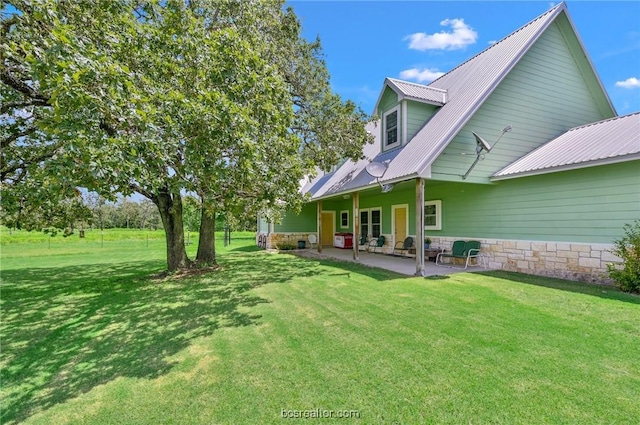 rear view of house with a patio area and a yard