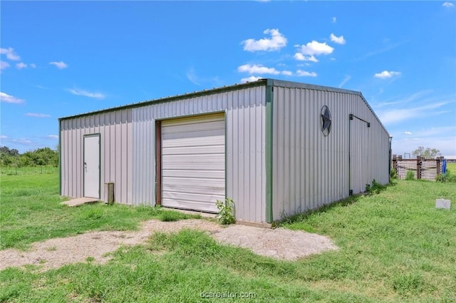 view of outdoor structure with a garage and a yard