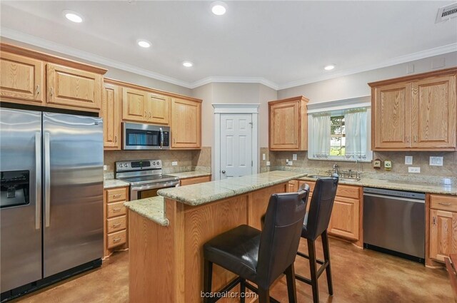 kitchen featuring a kitchen bar, tasteful backsplash, a center island, and stainless steel appliances