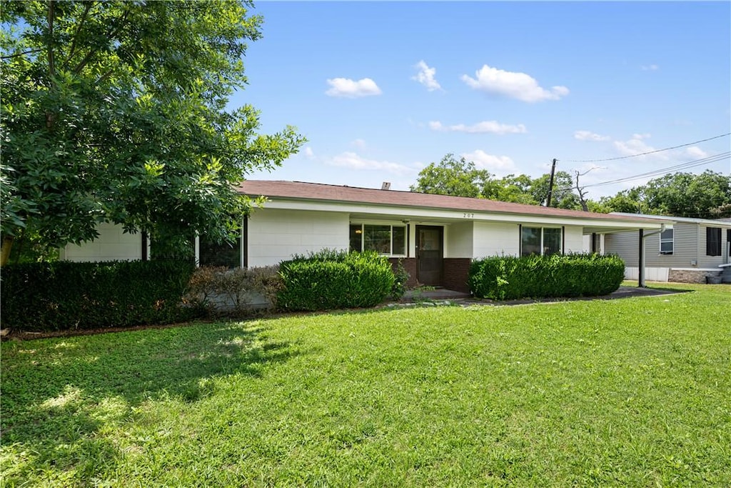 ranch-style house with a front lawn and a carport