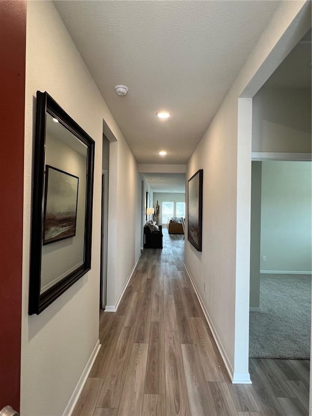 corridor featuring hardwood / wood-style flooring and a textured ceiling