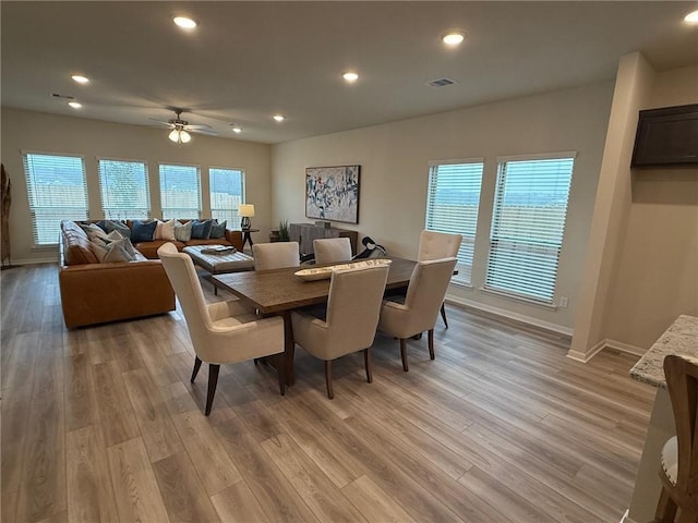 dining space with ceiling fan and light wood-type flooring