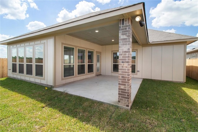 rear view of property featuring a patio and a lawn