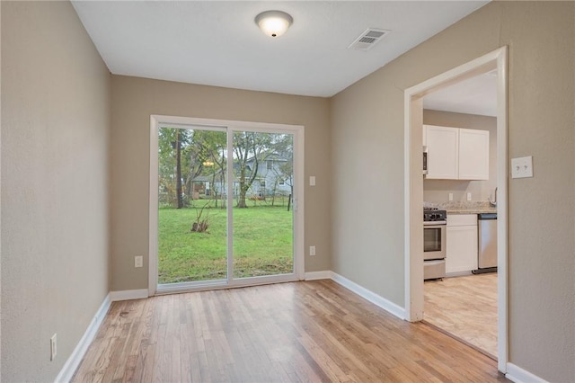 spare room featuring light hardwood / wood-style floors