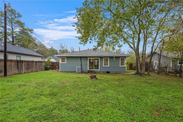 rear view of house with a lawn and central AC