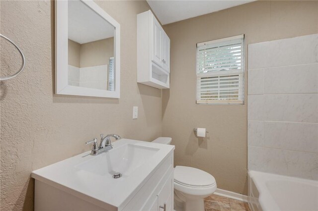 bathroom featuring vanity, toilet, and a washtub