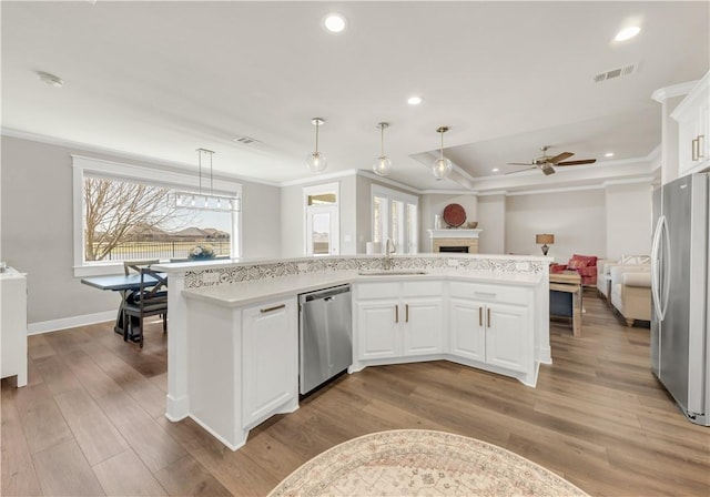 15658 Long Creek Ln, College Station, TX 77845 - kitchen with stainless steel appliances, a fireplace, a sink, visible vents, and open floor plan