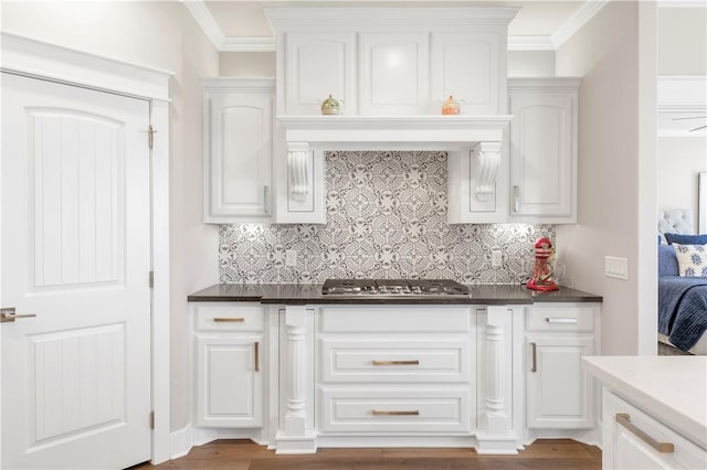 15658 Long Creek Ln, College Station, TX 77845 - kitchen with crown molding, dark countertops, white cabinets, and stainless steel gas stovetop