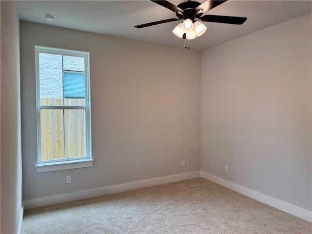 spare room featuring carpet flooring, baseboards, and a ceiling fan