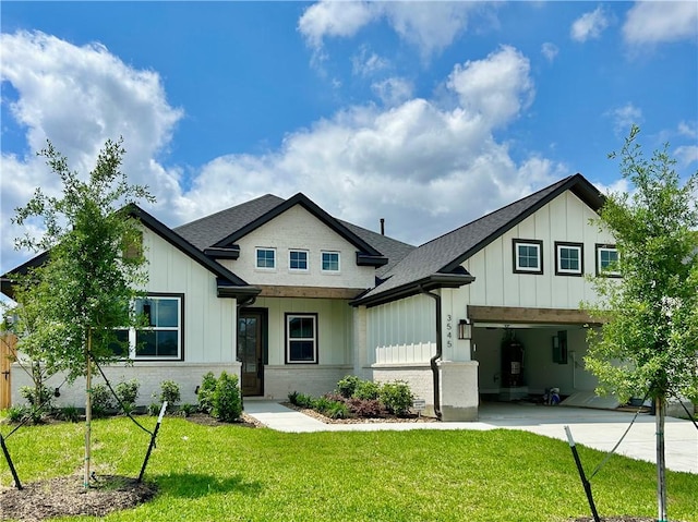 modern farmhouse with board and batten siding, a front yard, a shingled roof, and driveway