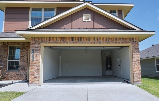 2011 Stubbs Dr, Bryan, TX 77807 - view of front of home featuring concrete driveway, brick siding, board and batten siding, and a garage