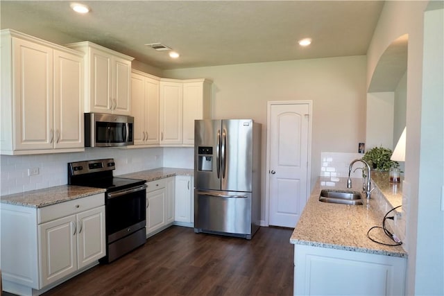 2011 Stubbs Dr, Bryan, TX 77807 - kitchen with stainless steel appliances, a sink, light stone countertops, backsplash, and recessed lighting