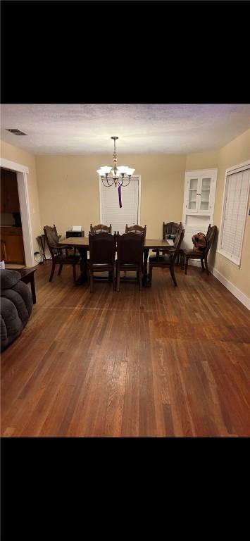 dining room featuring dark wood-type flooring and a notable chandelier