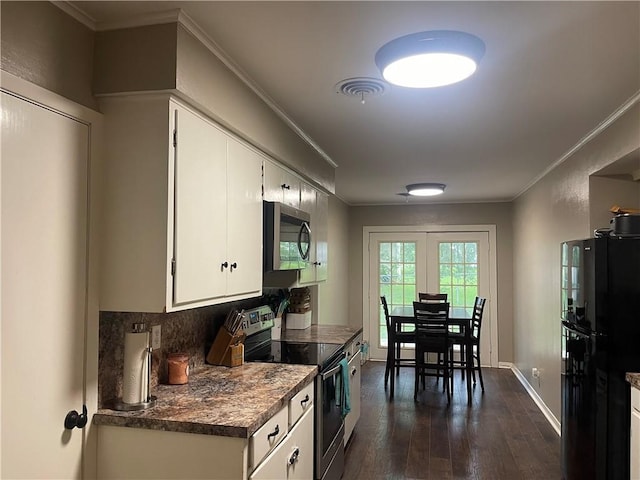 508 Victoria St, Navasota, TX 77868 - kitchen with appliances with stainless steel finishes, dark wood-style floors, white cabinetry, dark countertops, and ornamental molding