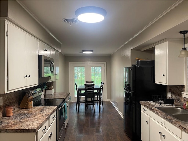 508 Victoria St, Navasota, TX 77868 - kitchen featuring appliances with stainless steel finishes, dark wood-style floors, decorative backsplash, white cabinets, and crown molding