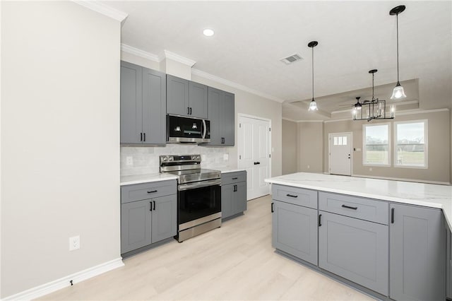 kitchen with visible vents, backsplash, ornamental molding, gray cabinets, and appliances with stainless steel finishes