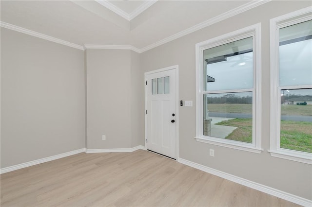 foyer with baseboards, crown molding, and light wood-style floors