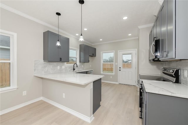 kitchen featuring a sink, appliances with stainless steel finishes, a peninsula, and gray cabinets