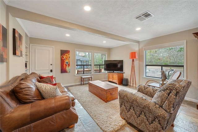 living room featuring beamed ceiling and a textured ceiling