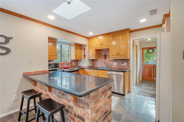 kitchen with a kitchen breakfast bar, a skylight, decorative backsplash, kitchen peninsula, and stainless steel appliances