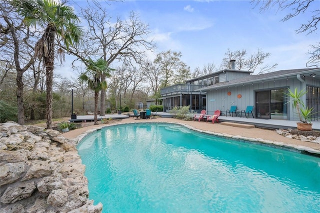 view of swimming pool featuring a patio area and a sunroom