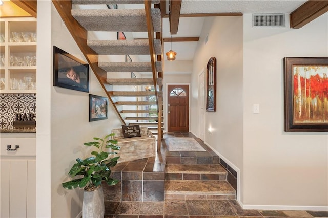 foyer entrance featuring beamed ceiling