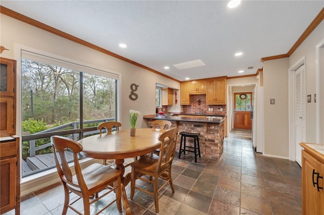 dining space featuring crown molding and sink