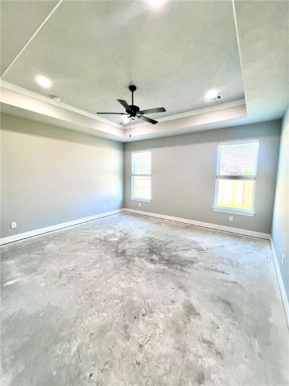 empty room with a tray ceiling and ceiling fan