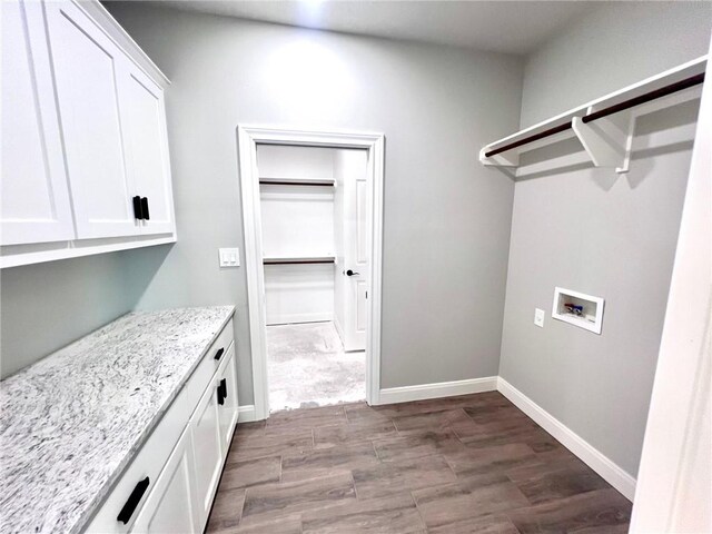 laundry area with hookup for a washing machine, hardwood / wood-style floors, and cabinets