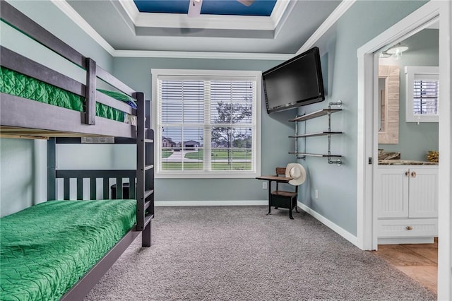 bedroom with carpet flooring, crown molding, and a tray ceiling