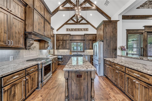 kitchen featuring appliances with stainless steel finishes, backsplash, light stone counters, beam ceiling, and a center island