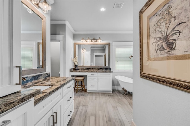 bathroom with a tub to relax in, crown molding, vanity, and hardwood / wood-style flooring