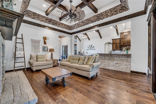 living room featuring beamed ceiling, ceiling fan with notable chandelier, dark hardwood / wood-style flooring, and a high ceiling