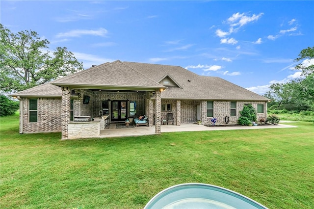 rear view of property with a lawn and a patio area