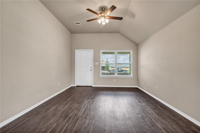 empty room featuring visible vents, baseboards, vaulted ceiling, dark wood finished floors, and a ceiling fan