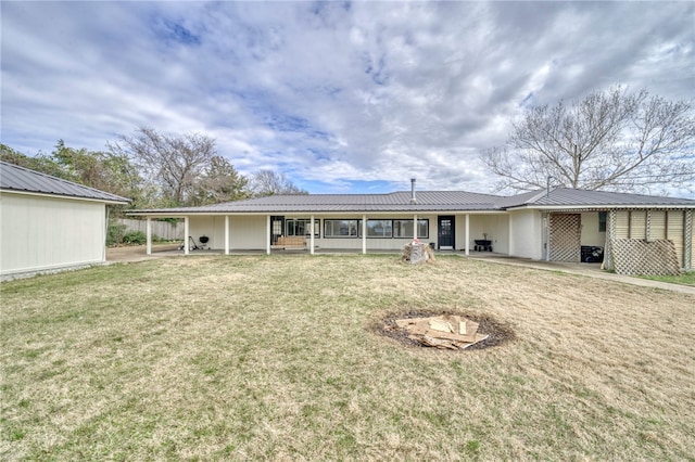 rear view of house featuring a lawn and a carport