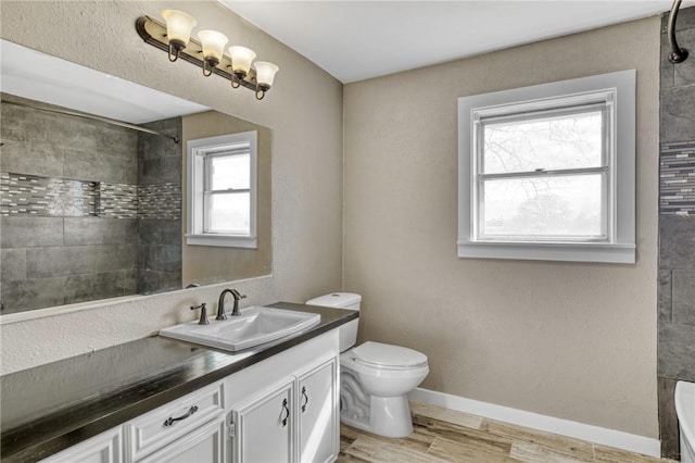 full bathroom featuring tiled shower / bath combo, vanity, hardwood / wood-style floors, and toilet