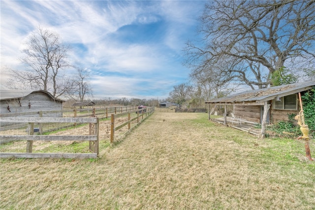 view of yard with an outbuilding and a rural view