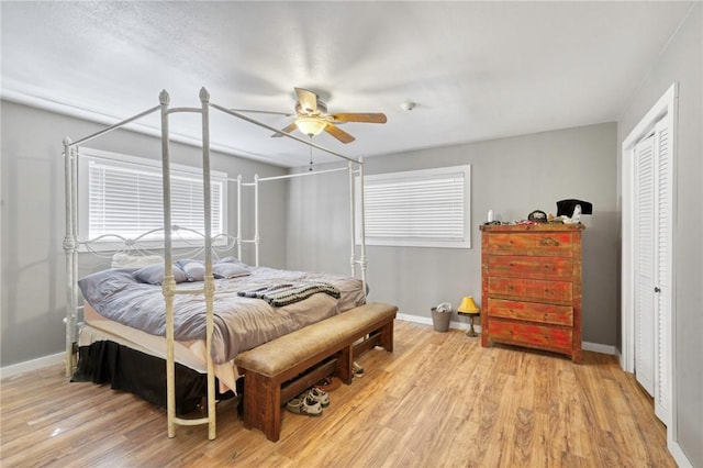 bedroom with ceiling fan, a closet, and light hardwood / wood-style flooring