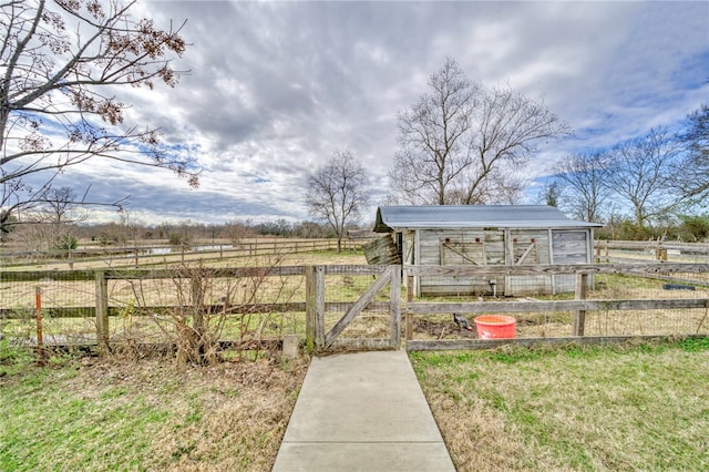 view of yard featuring a rural view and an outbuilding