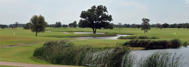 view of home's community featuring a lawn and a water view