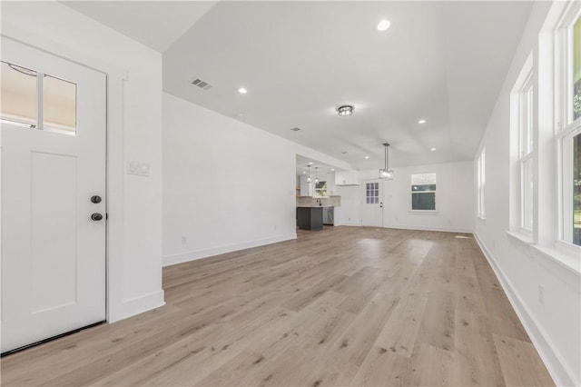 unfurnished living room featuring a healthy amount of sunlight and light wood-type flooring