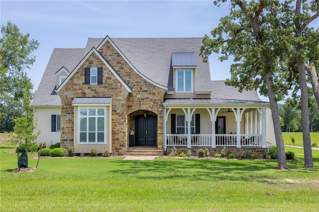 10560 St John Dr, Iola, TX 77861 - view of front of house featuring a standing seam roof, covered porch, stone siding, and a front lawn