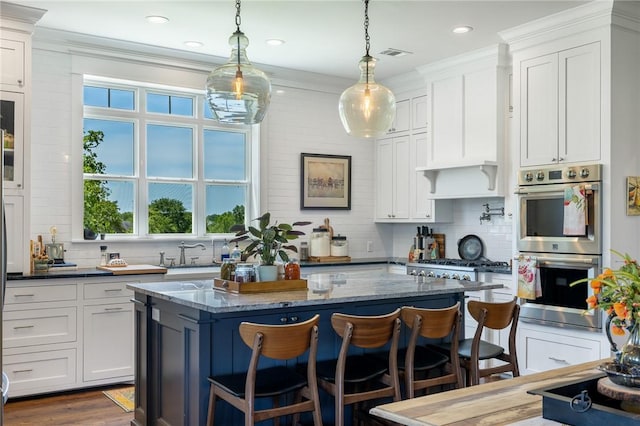 10560 St John Dr, Iola, TX 77861 - kitchen featuring appliances with stainless steel finishes, a kitchen island, backsplash, a breakfast bar, and recessed lighting