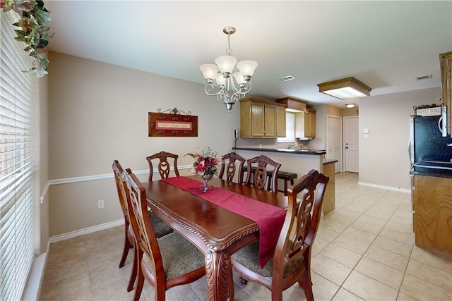 tiled dining room with a notable chandelier and sink