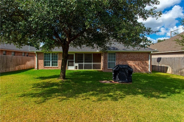 rear view of house featuring a yard