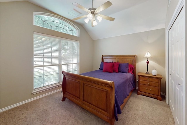 carpeted bedroom featuring ceiling fan, vaulted ceiling, and a closet