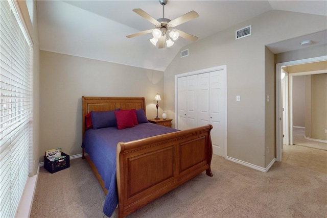 bedroom featuring light carpet, lofted ceiling, a closet, and ceiling fan