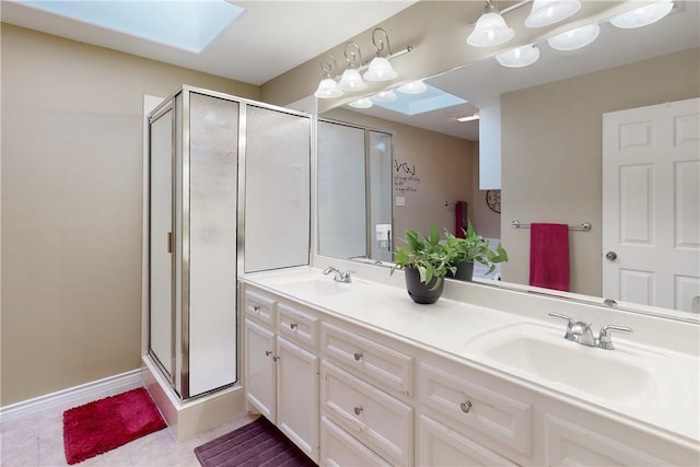 bathroom with vanity, a skylight, a shower with shower door, and tile patterned floors